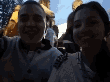 a man and a woman are posing for a picture and smiling for the camera