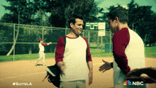 two men talking on a baseball field with nbc written on the bottom right