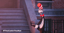 a cat in a red and white hat is standing in front of a staircase