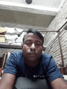 a man wearing a blue shirt that says ' a ' on it