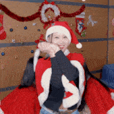 a woman is wearing a santa hat and a cape