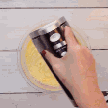 a mixer is being used to mix eggs into a bowl