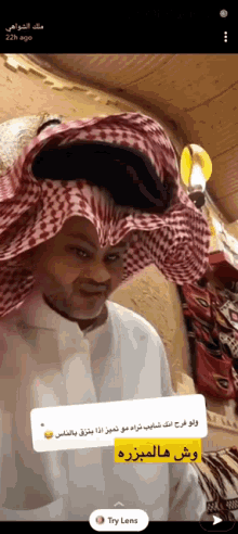 a man wearing a checkered head scarf and a white shirt has a try lens sticker next to him