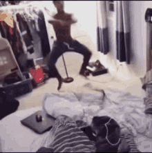 a man without a shirt is dancing in a messy room