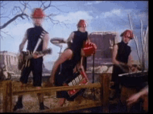 a group of people wearing hard hats are playing instruments on a stage