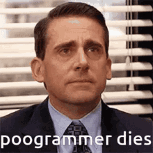 a man in a suit and tie is sitting in front of a window with blinds and a caption that says poogrammer dies .