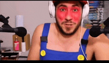 a man with red paint on his face is wearing headphones .