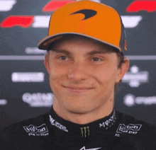 a man wearing a mclaren hat and a monster shirt smiles