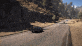 a car is driving down a road in the desert