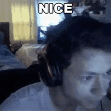 a man wearing headphones has the word nice on his head
