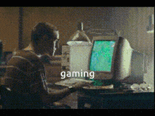 a man is sitting in front of a computer with the word gaming on the bottom