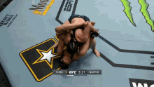 a couple of women are wrestling on a mat with a star on it .