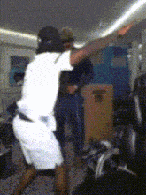 a man in a white shirt and shorts is pointing