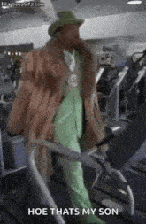 a man in a fur coat and hat is walking on a treadmill in a gym .