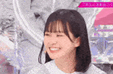 a girl with short hair is smiling and making a funny face with her eyes closed