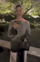 a woman holding a card that says bazaar