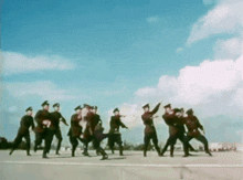 a group of soldiers are dancing on a runway