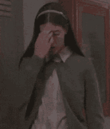 a woman with long hair and a headband on her head is standing in a locker room .