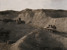 a group of people are riding in a vehicle on a dirt road .