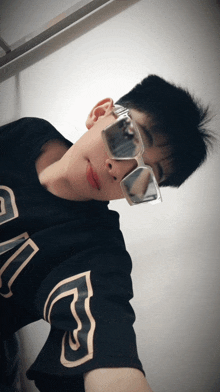 a man wearing sunglasses and a black shirt with the letter g on the sleeve