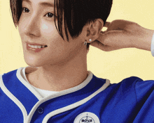 a person wearing a blue shirt with boys embroidered on it