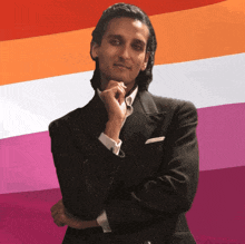 a man in a suit is standing in front of a lesbian flag