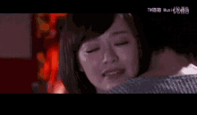 a woman is crying while hugging a man and the words music are on the bottom