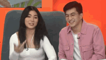 a man and a woman are sitting next to each other on a chair .