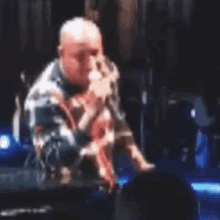 a man is singing into a microphone on a stage in front of a crowd .
