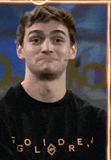 a man is wearing a black shirt that says goldrev