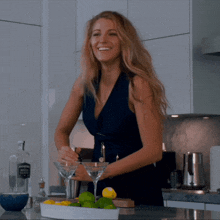 a woman in a blue dress is preparing a martini in front of a bottle of vodka
