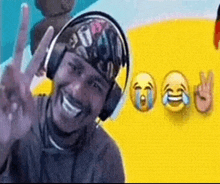a man wearing headphones is smiling and giving a peace sign in front of a yellow background .