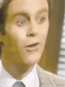 a close up of a man in a suit and tie