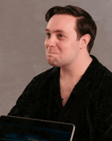a man in a black shirt is looking at a tablet