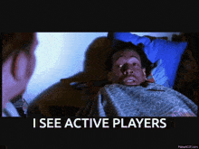 a man laying on a bed with the words " i see active players " next to him