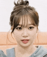 a close up of a woman 's face with her hair in a bun and fringe .