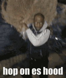 a man is carrying a large object on his shoulders and the words hop on es hood are on the bottom of the image .