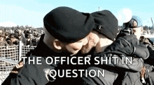 two men in military uniforms are hugging each other in front of a crowd of people .