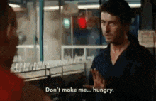 a man is talking to another man in a restaurant and says `` don 't make me ... hungry '' .