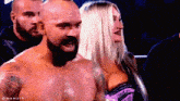 a man with a beard is standing next to a woman with a bra