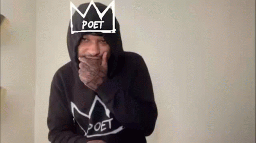 a man wearing a hoodie with a crown on his head is laughing .