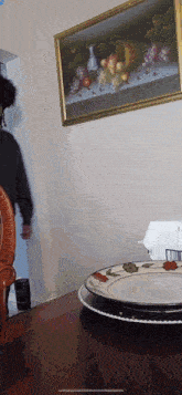 a person standing in front of a framed picture of fruit