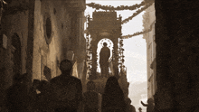 a group of people are walking down a narrow street