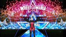 a woman stands on a stage in front of a wrestlemania logo