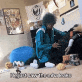 a person sitting on the floor with the words he just saw the mha leaks