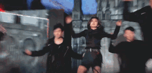 a woman in a black dress is dancing with a group of people