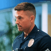 a man in a police uniform has a badge on his chest that says police