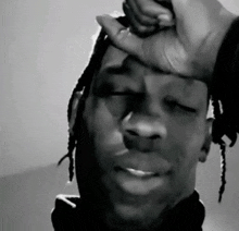 a black and white photo of a man holding his head
