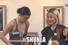 a woman with a name tag that says shuvee is standing next to another woman
