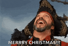 a man in a pirate hat is laughing and saying merry christmas !